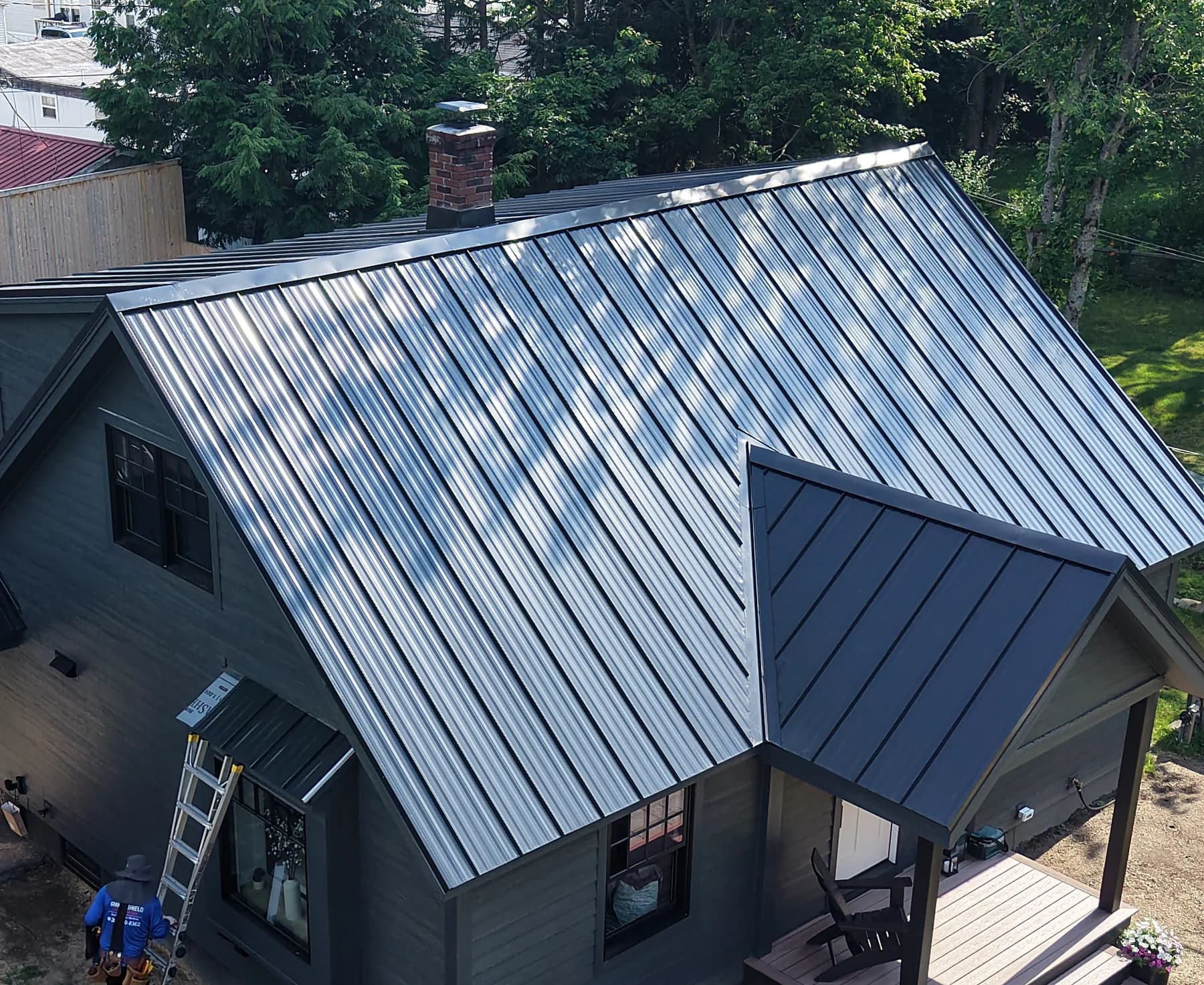 Matte black standing seam metal roof installation on a home in Brunswick, Maine by GraniteShield Roofing & Exteriors